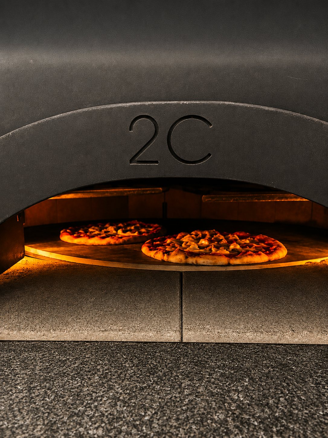 Le four napolitain siglé 2C, deux pizzas en cuisson sur la sole