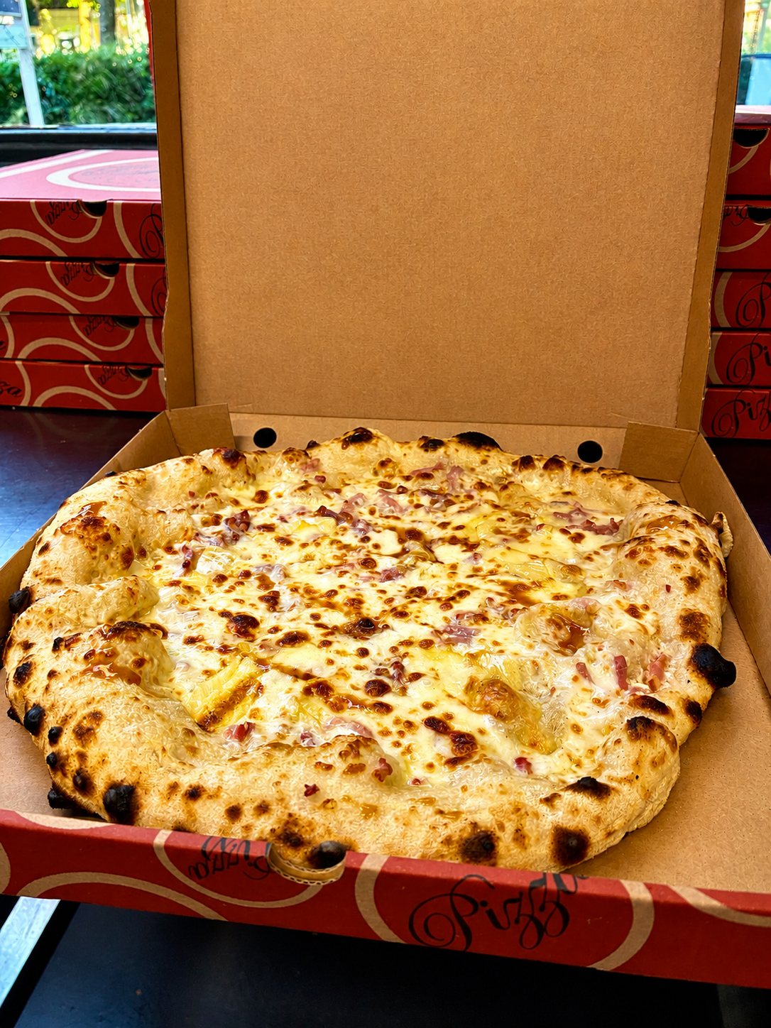 Pizza blanche dans sa boîte : crème, mozzarella et lardons